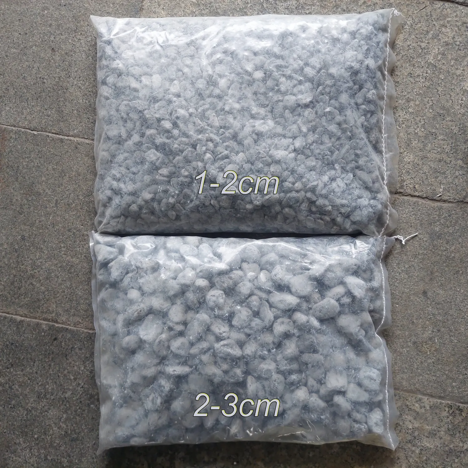 Sỏi đen tự nhiên quay-bao 12kg 3 Hai bao sỏi đen tự nhiên quay quy cách đóng bao 12kg với hai kích thước phân loại 1-2cm và 2-3cm.